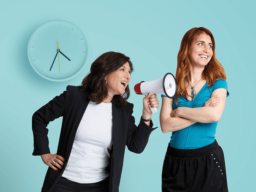 2 femmes souriantes dont l'une avec un porte voix