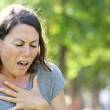 Jeune femme qui se tient le cœur, l'air fatigué