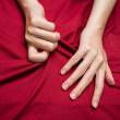 Mains de femmes, serrent des draps rouges