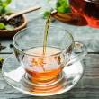 Tasse de thé transparente, théière qui coule, feuilles de menthe