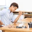 Un homme à son poste de travail est mal installé et a mal au dos