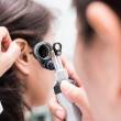 Médecin qui ausculte l'oreille d'une patiente 
