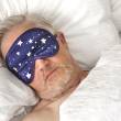Homme dormant dans son lit avec un bandeau sur les yeux