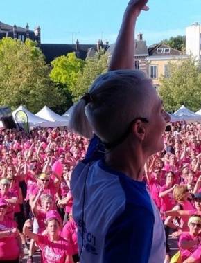 Foulées de la cathédrale de Chartres - Femme en tenue de sport qui brandit le bras, centaines de femmes avec T-shirts roses