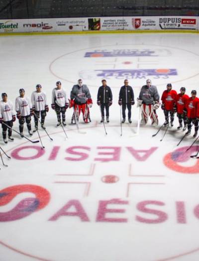 Joueurs de hockey Boxers de Bordeaux, autour du logo Aésio mutuelle, patinoire