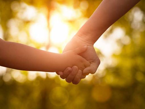 Adulte qui tient la main d'un enfant