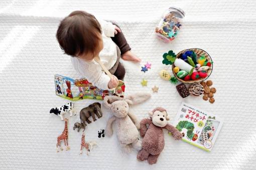 un enfant est entouré de plusieurs jouets 