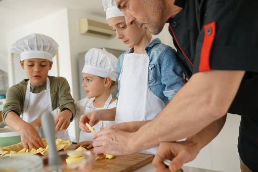 Un cuisinier apprend des enfants à cuisiner