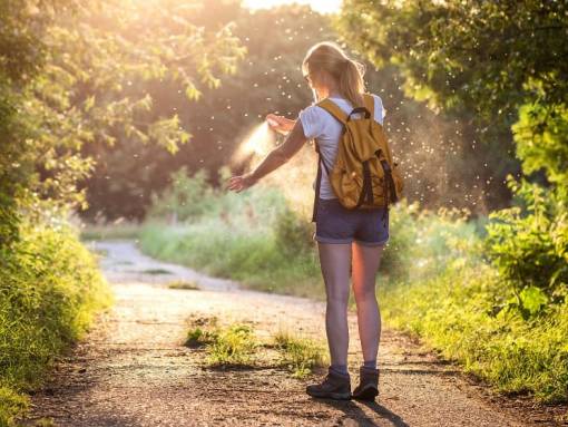 Une femme en randonnée se vaporise du spray anti-moustiques