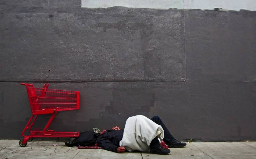Homme couché par terre, caddie rouge vide
