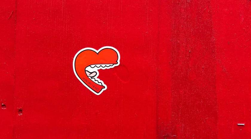 Etiquette de coeur avec une bouche, collée sur un mur rouge