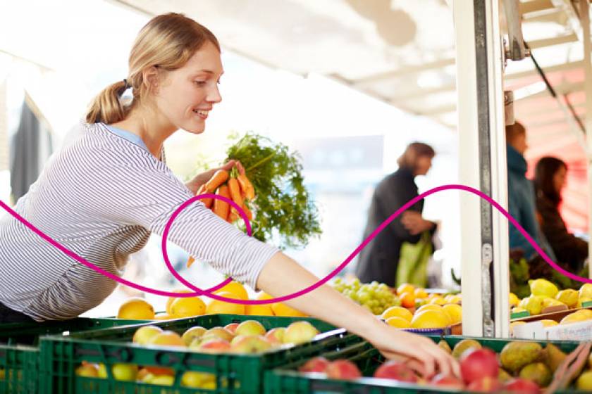Femme qui choisit des légumes au marché