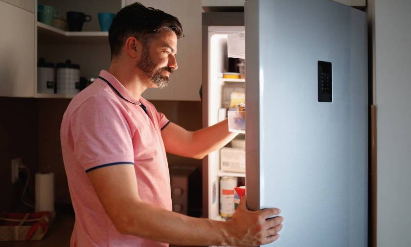 Homme avec lumière du frigo ouvert