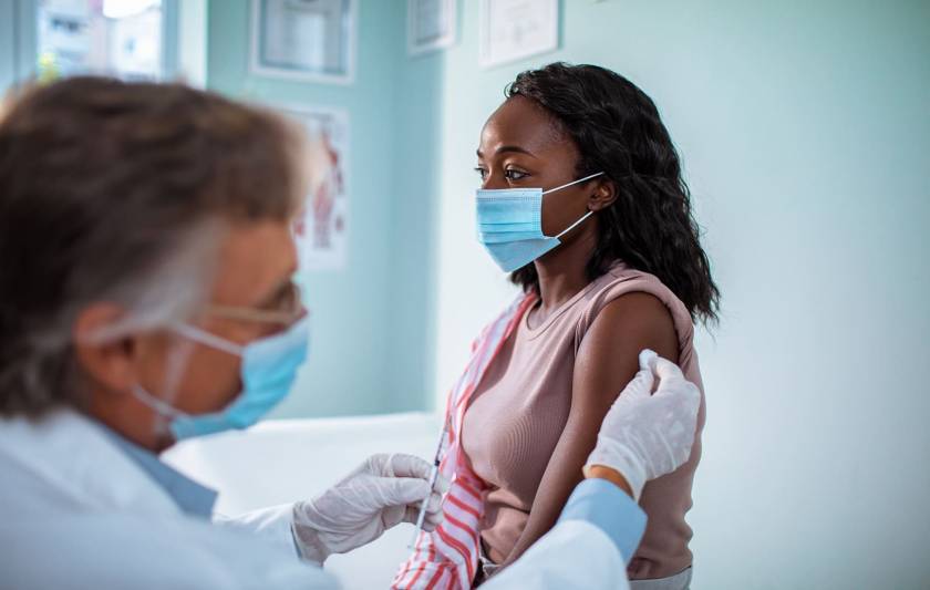 Femme qui reçoit une piqure, médecin avec aiguilles et gants bleus, masque bleu chirurgical