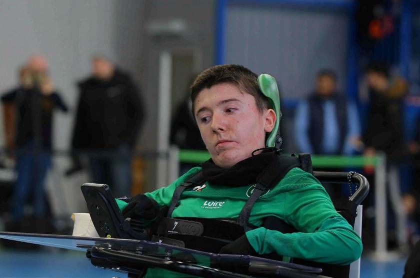 Baptiste Devaux en fauteuil roulant, pilote le robot ASSE Cœur vert foot fauteuil