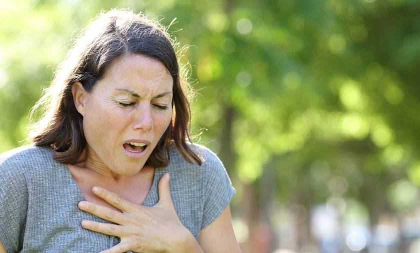 Jeune femme qui se tient le cœur, l'air fatigué