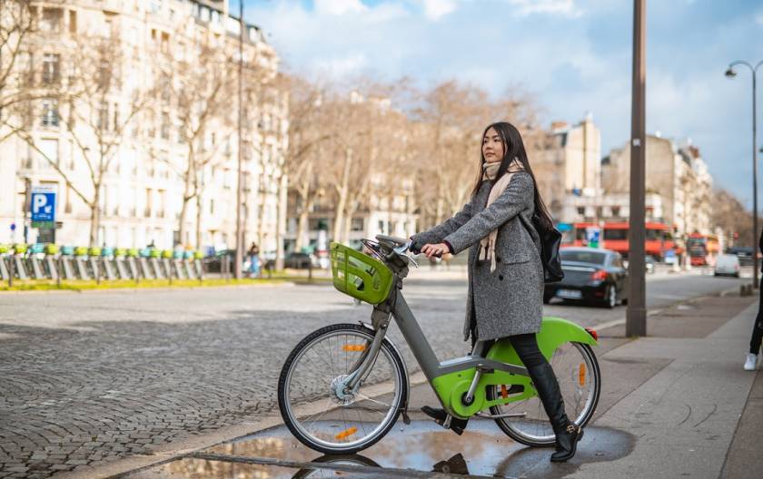 Vélo électrique de location, vert, femme asiatique, parking