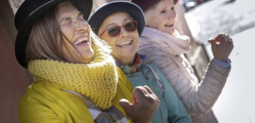 3 femmes seniors, rigolent, avec chapeaux et lunettes colorées