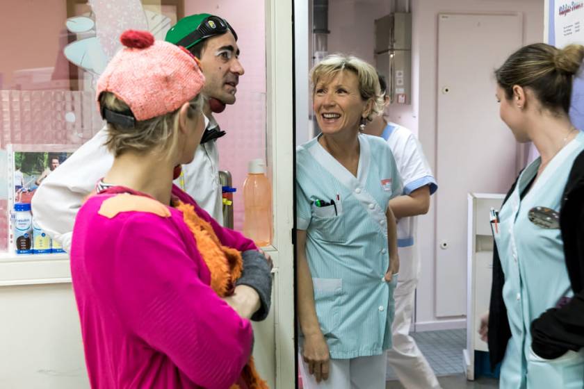 Clowns Bertille et Ketchup dans le couloir de l'hôpital, discutent avec des infirmières en blouse