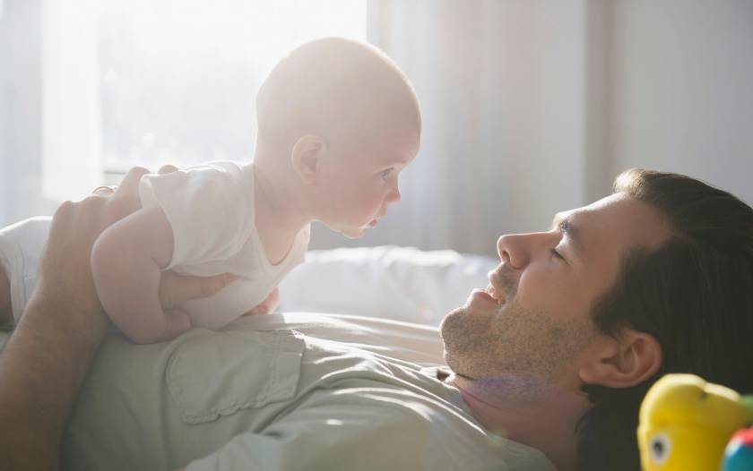 Homme qui joue avec son bébé, allongé sur le dos