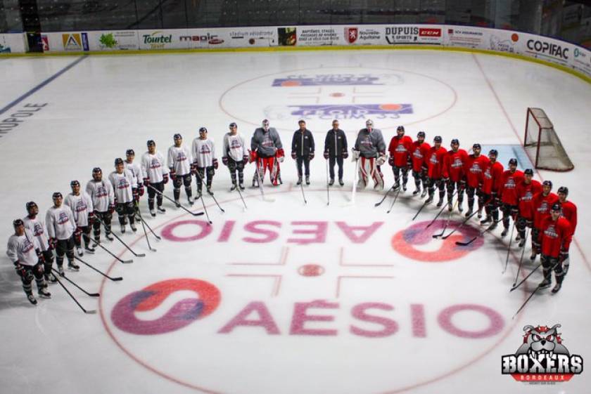 Joueurs de hockey Boxers de Bordeaux, autour du logo Aésio mutuelle, patinoire