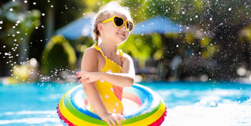 Petite fille en maillot, lunettes de soleil en forme de cœur