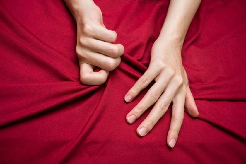 Mains de femmes, serrent des draps rouges