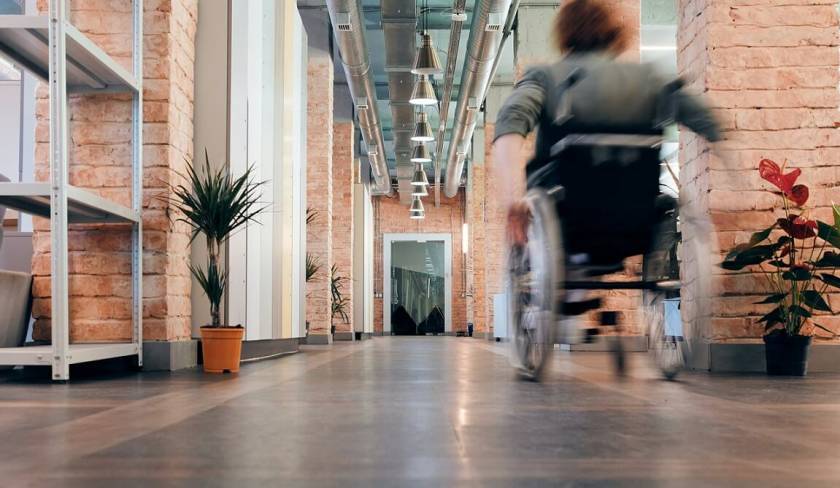 Femme en fauteuil roulant, couloir d'entreprise