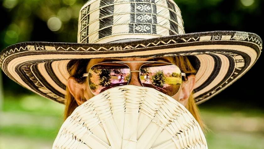 Femme avec chapeau, lunettes de soleil et éventail