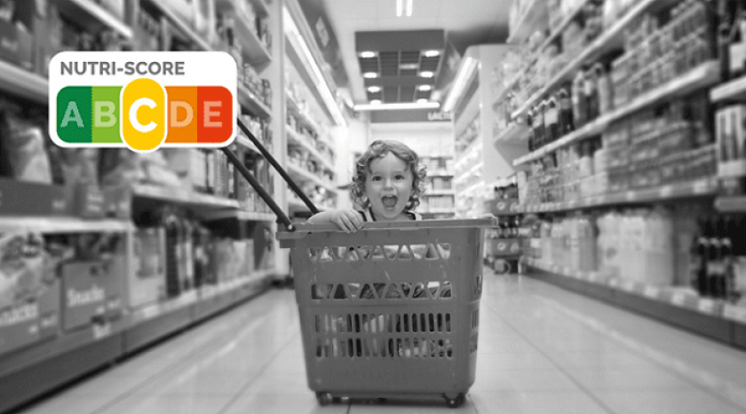 Enfant dans un caddie, rayons de supermarché. Logo Nutriscore C orange
