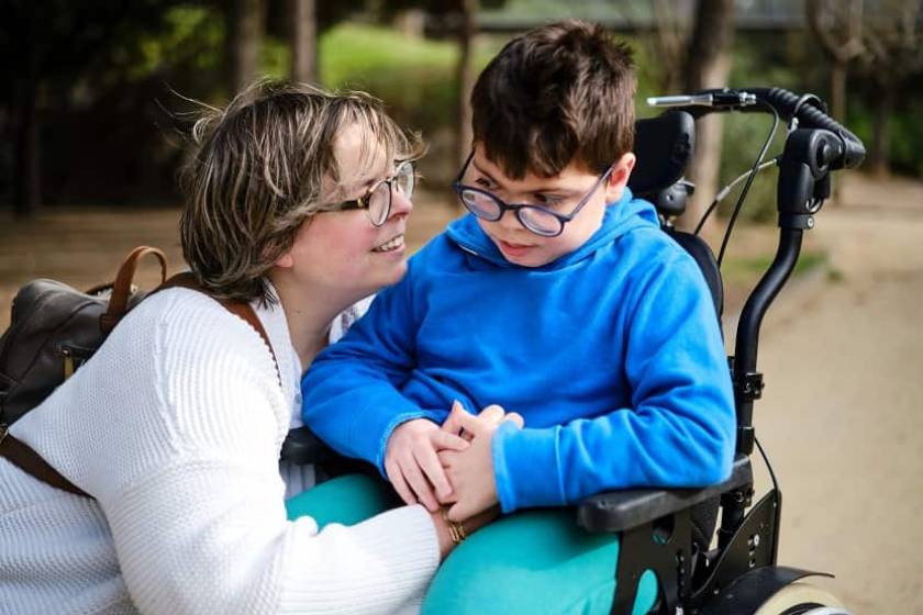 une maman près de son fils handicapé dans un parc