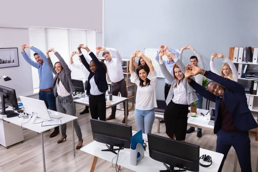 Des salariés de bureaux s'étirent dans une salle tous ensemble