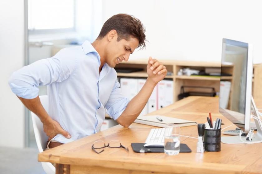 Un homme à son poste de travail est mal installé et a mal au dos