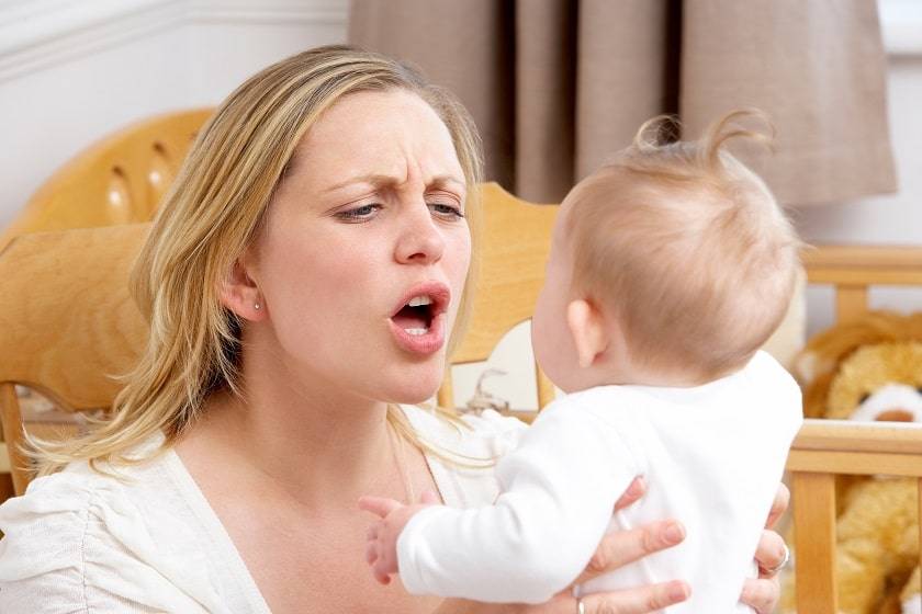 Femme énervée avec un bébé dans les bras