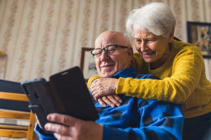 Un senior regarde son téléphone portable avec sa femme à ses côtés 