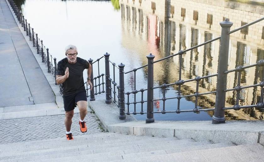 Un homme fait un footing et grimpe des escaliers en extérieur