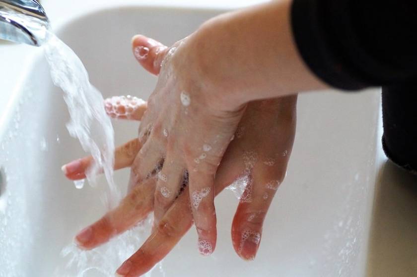 Une personne se lave les mains au lavabo