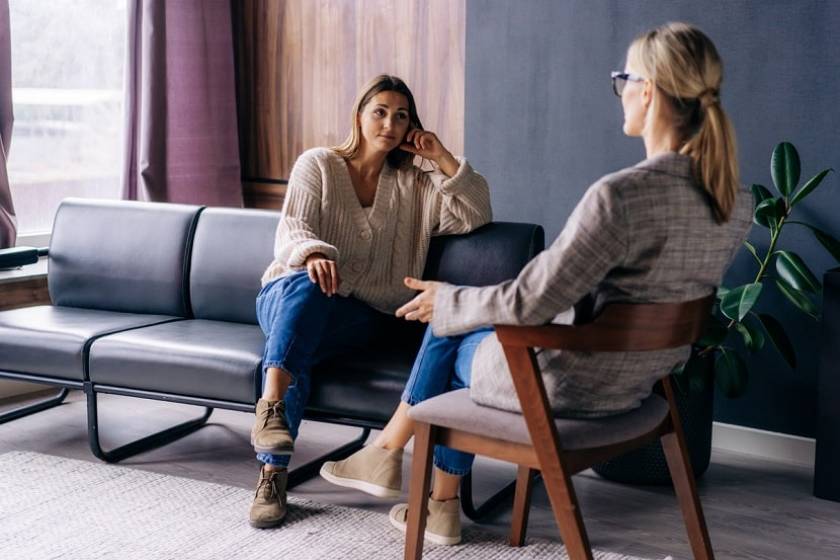 Une femme assise sur un fauteuil consulte une psy