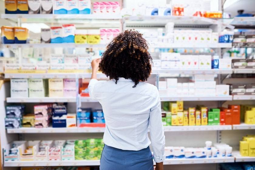 Femme devant un étagère de méicaments