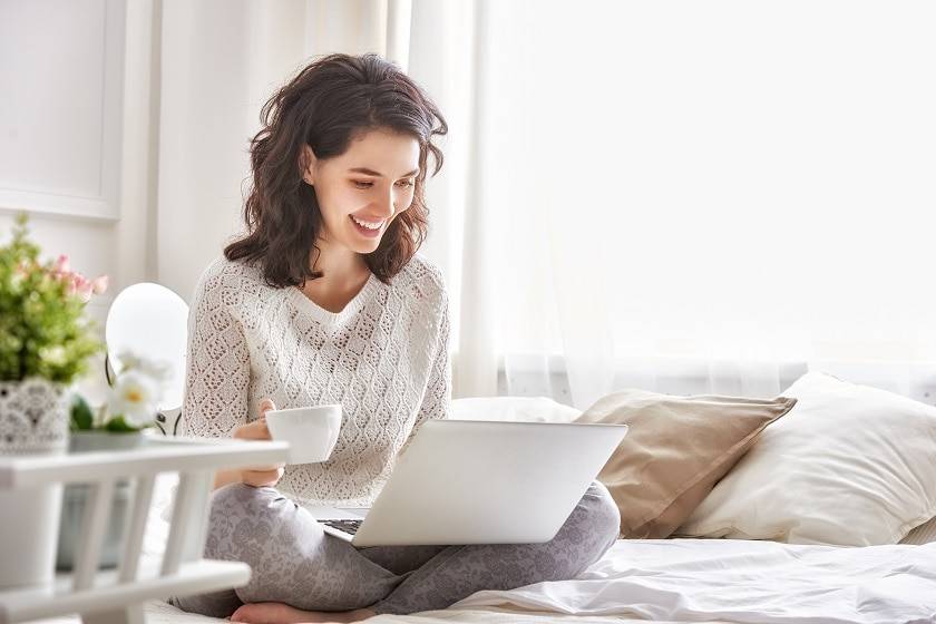 Femme souriante devant un ordinateur