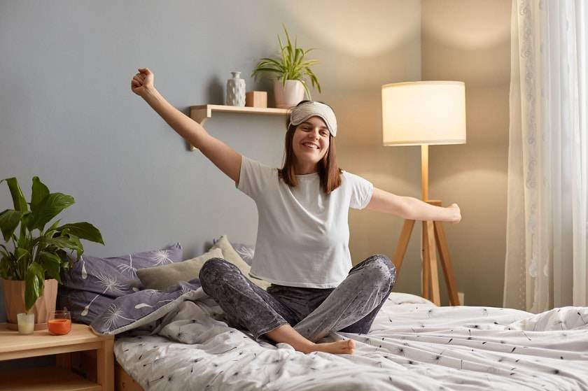 Femme qui s'étire dans un lit