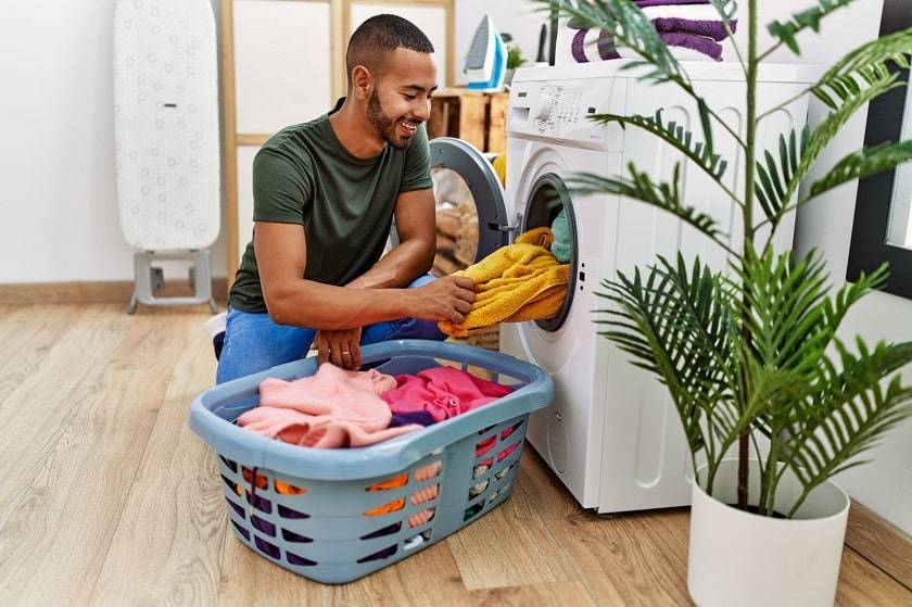 Homme sortant des vêtements d'une machine à laver