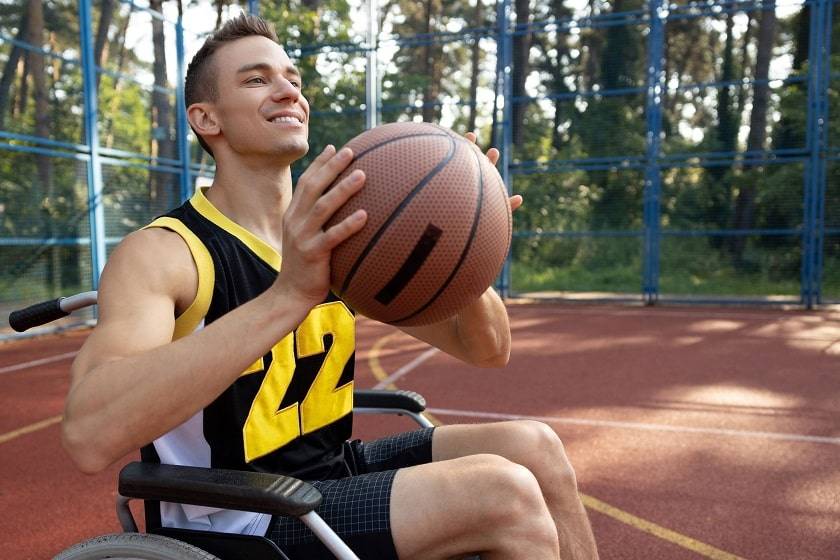 Homme en fauteuil roulant jouant au basket 