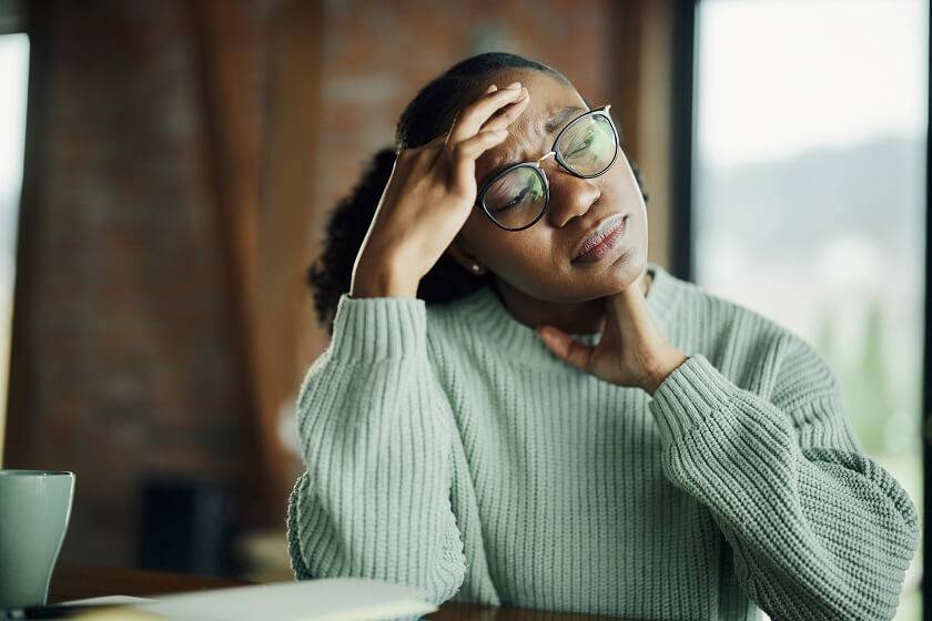 Femme se tenant la tête avec sa main droite