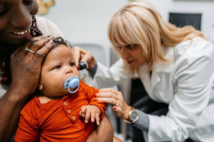 Docteur qui ausculte un bébé