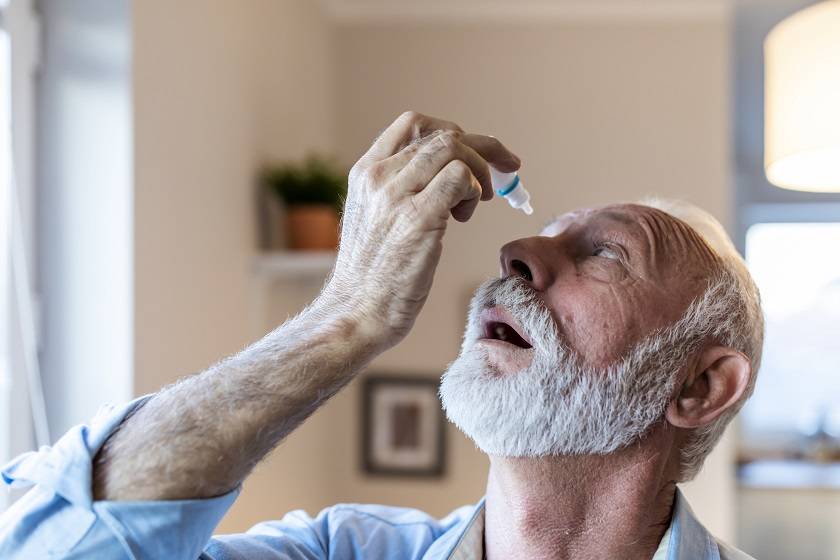 Homme se mettant des gouttes dans les yeux