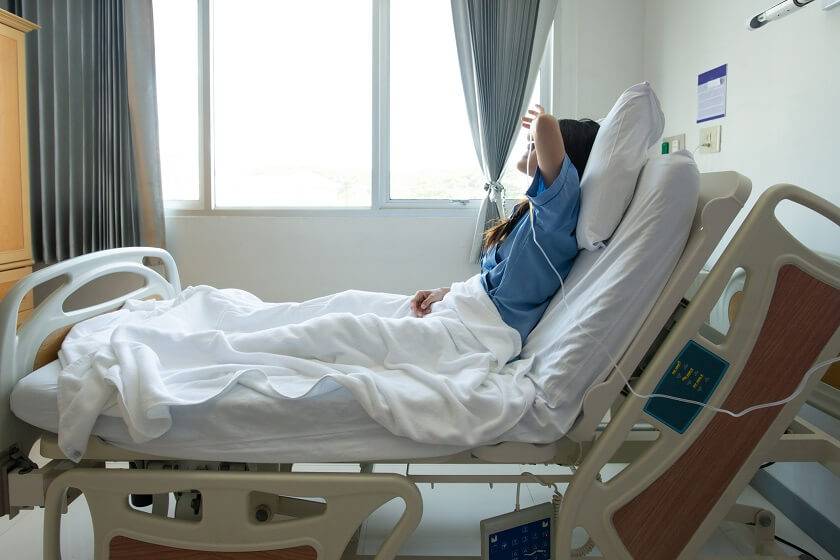 Femme allongée sur un lit d'hôpital