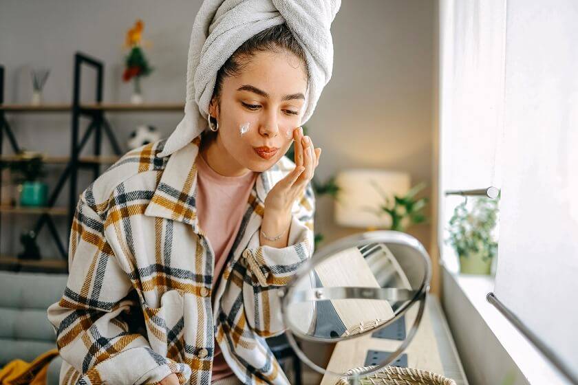 Femme s'appliquant de la crème sur le visage