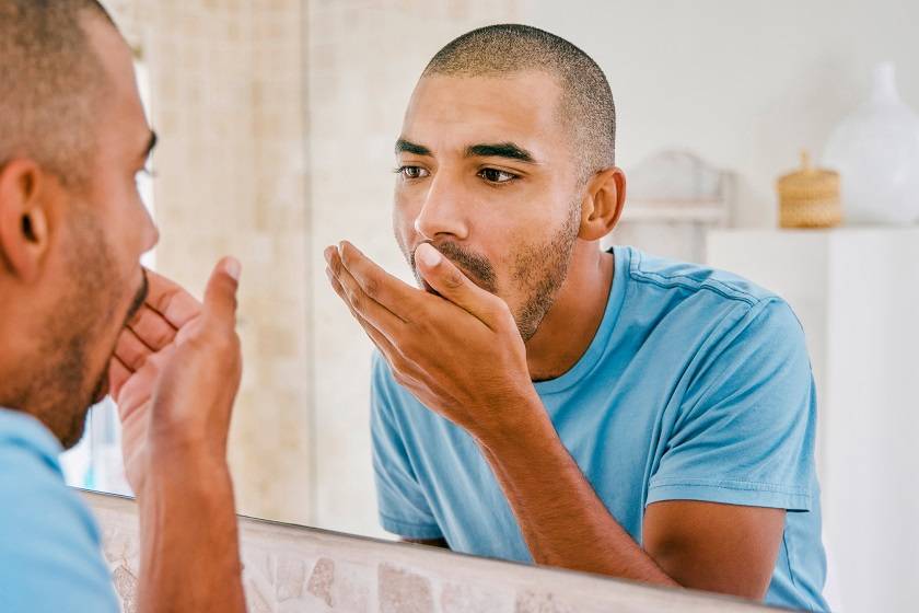 Homme sentant son haleine