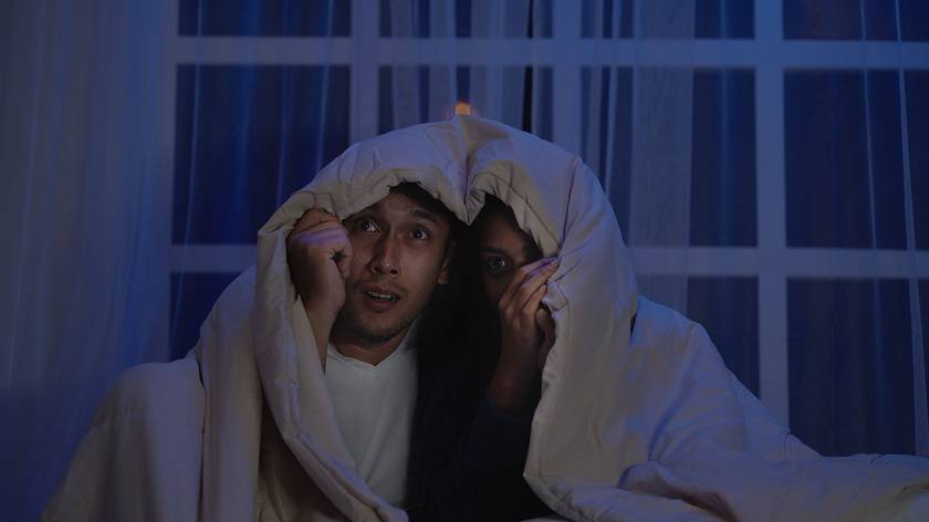 Un couple se cachant sous une couverture